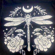 the dragonfly is sitting on top of roses with crescents and stars around it