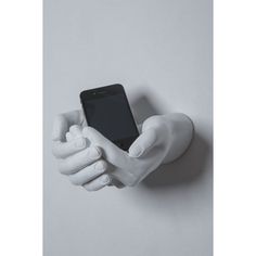 a white hand holding a cell phone in it's right hand, against a gray background