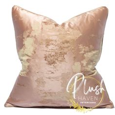 a pink and gold pillow on a white background with an image of trees in the distance