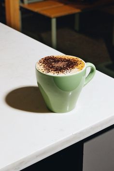 a cup of coffee sitting on top of a white counter