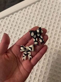 three black and white bows in someone's hand