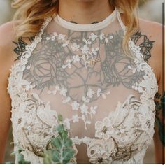 a close up of a woman wearing a wedding dress with flowers on it's neck