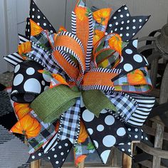 a black and white polka dot bow with orange flowers on it's front door