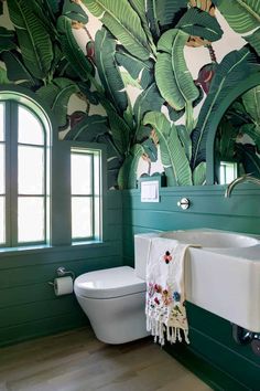 a bathroom with green painted walls and white fixtures