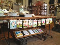 there are many cards on the cart in this shop that is decorated with flowers and birds