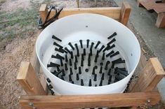 a white bucket filled with lots of black screwdrivers in front of a wooden bench