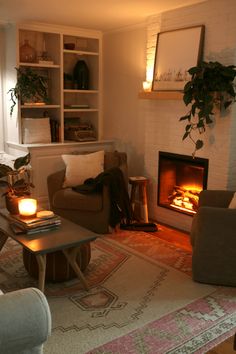 a living room filled with furniture and a fire place next to a book shelf full of books