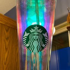 the starbucks cup has been decorated with colorful lights