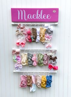 there are many small bows hanging on the wall next to a sign that says mackle