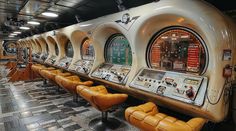 a row of yellow chairs sitting next to each other in front of an old fashioned machine