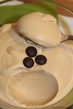 a spoon full of ice cream with chocolate chips on top and some milk in the bowl