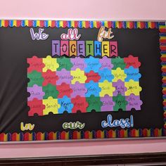 a bulletin board that says we all fit together with puzzle pieces in the shape of a map