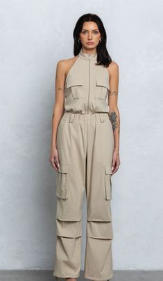 Zip-up cargo jumpsuit Halter neck Zipper closure Elastic waistband Drawstrings on leg opening Size recommendation: true to size Fitted Cargo Style Jumpsuits And Rompers, Cargo Style Jumpsuits And Rompers For Spring, Fitted Cargo Style Jumpsuits And Overalls, Fitted Cargo Style Overalls And Jumpsuits, Fitted Cargo Style Jumpsuits And Rompers For Spring, Spring Cargo Style Fitted Jumpsuits And Rompers, Fitted Cargo Style Jumpsuits For Spring, Summer Zipper Jumpsuits And Rompers In Overall Style, Cargo Style Overall Jumpsuit For Summer