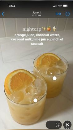 two glasses filled with orange juice sitting on top of a white counter next to each other