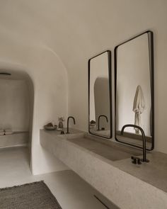 a bathroom with two sinks and mirrors on the wall