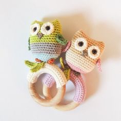 two crocheted owls sitting next to each other on top of a white surface