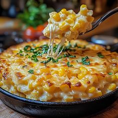 a spoonful of macaroni and cheese is being lifted from a skillet