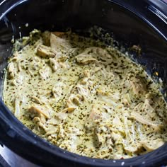 a crock pot filled with chicken and broccoli covered in seasoning sprinkles