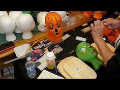 a person working on a pumpkin mask at a table with other crafting supplies and tools