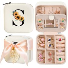 an assortment of rings and bracelets in a white case with a bow on the side