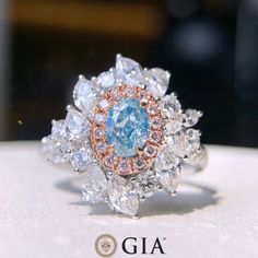 Bienvenue chez Odyssée Joaillerie, nous nous spécialisons dans le diamant coloré et les différentes Pierre précieuse et fine, Nous offrons un grand choix: blanc, ou jaune, ou rose, platine, vos bijoux sont finement fabriqués pour une qualité exceptionnelle!  Symbole d'amour par excellence, le diamant est une belle preuve d'amour. Le joyau de vos rêves est le vôtre! Détails : Marque: Odyssée Joaillerie Métal : or blanc et rose 18k * Pierre centrale : Diamant Bleu très Clair 0,49ct SI2 * Pierres l Dig Jewelry, Oval Halo Diamond Ring, Oval Halo Engagement Ring, Vintage Style Engagement Rings, Blue Diamond Ring, Colorless Diamond, Bracelet Design, Engagement Rings Oval, Halo Diamond Ring