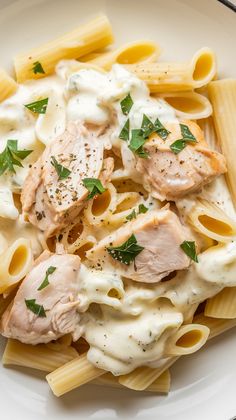 a white plate topped with pasta and chicken