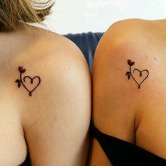 two women with tattoos on their backs showing the same heart and flower tattoo designs as they both appear to be facing each other