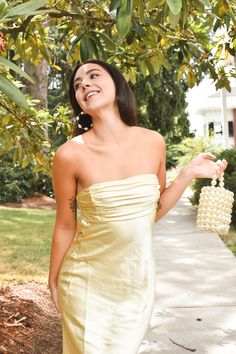 Get ready to turn heads at any wedding with the Andie Butter Yellow Silky Midi Dress! This is the ultimate yellow wedding guest dress. Cut from a luxurious butter yellow silky fabric, this classic strapless sheath dress features a low back and a tie back for an effortlessly elegant look. Runs slim. Yellow Wedding Guest Dress, Yellow Wedding Guest Dresses, Strapless Sheath Dress, Dresses Date Night, Wedding After Party, Cool Girl Style, Beach Bride, Casual Day Dresses, Butter Yellow