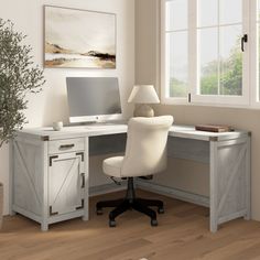 a white desk with a computer on it in front of a window and a potted plant