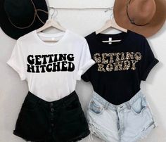 two t - shirts that say getting hitched and leopard print on them, hanging up against a wall