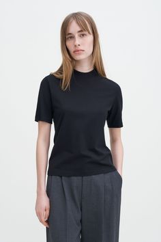 Mock Neck Tee Classic Stretch T-shirt For Workwear, Cotton T-shirt With Ribbed Collar For Work, Classic Short Sleeve T-shirt For Fall, Black Cotton Turtleneck Top, Black Turtleneck T-shirt, Classic Turtleneck Tops For Everyday, Classic Everyday Turtleneck Tops, Cotton Turtleneck Tops For Everyday, Black High Neck Classic Top