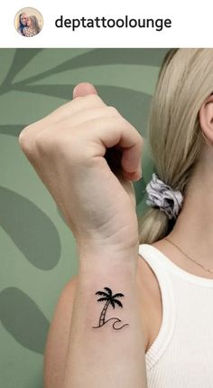 a woman with a small palm tree tattoo on her left arm and the word depattoolounge written in black ink