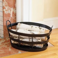 a metal basket with logs in it sitting on the floor