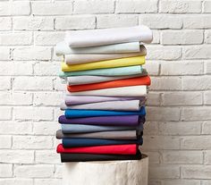 a stack of folded sheets in front of a brick wall