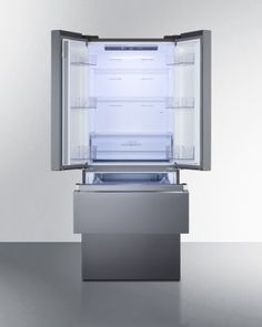 an empty refrigerator with its door open on a shiny surface in front of a white wall