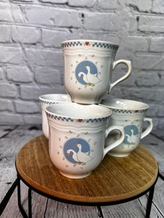 three coffee cups sitting on top of a wooden table