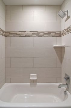 a white bath tub sitting inside of a bathroom next to a shower head and faucet