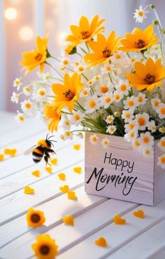 a vase filled with yellow and white flowers sitting on top of a table next to a bee