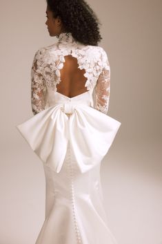 a woman in a wedding dress with an open back and lace on the top,