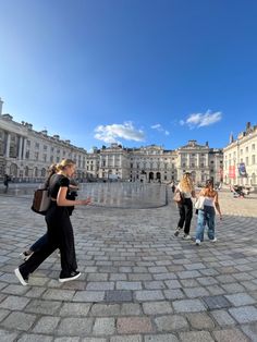 some people are walking around in the middle of a courtyard and there is no image here to provide a caption for