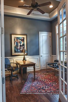 a living room with blue walls and wooden floors, an area rug on the floor