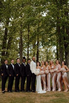 a group of people standing next to each other in front of trees