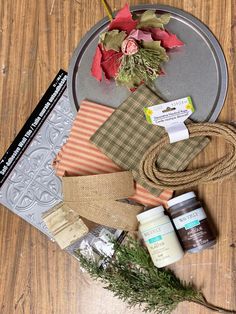 various items are laid out on top of a wooden table, including wrapping paper and flowers