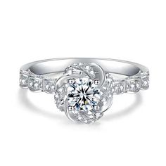 a white gold engagement ring with an intricate flower design and round brilliant diamonds on the band