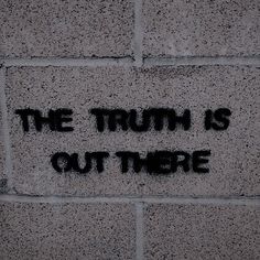 graffiti on the side of a brick wall that says, the truth is out there