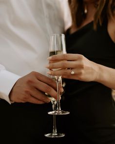 two people holding wine glasses in their hands