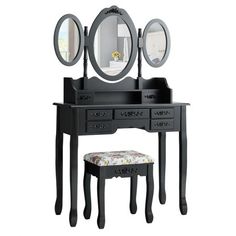 a black vanity table with two mirrors and a stool in front of it on a white background