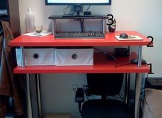 a desk with a computer on top of it and two drawers underneath the monitor screen