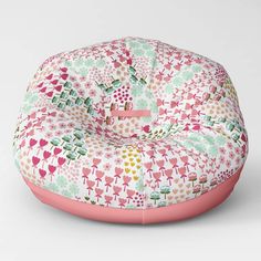 a pink and green flowered bean bag chair with an inner cushion on the bottom