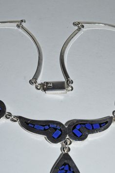 "Vintage Mexican Solid Sterling Silver Blue Chalcedony & Onyx Inlaid Linked Necklace Fancy links with inlaid stones of onyx and blue chalcedony. Center piece has a tear drop dangle with the same inlay. The back links are curved sterling links. Closes with a push in box clasp. Marked on the clasp S-149 MEXICO 925. Necklace is 16 1/2\" long. Center drop is 1\". This pendant is 1\" long x 5/8\" wide. This is a pre owned necklace in nice condition. 34.3 grams total weight Thanks for looking :)" Formal Blue Inlay Jewelry, Blue Sterling Silver Necklace With Inlay, Blue Necklace With Round Inlay, Necklace Fancy, Box Clasp, Vintage Mexican, Blue Chalcedony, Tear Drop, Silver Blue